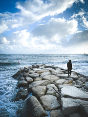 Fototapeta na wymiar man silhouette standing on the rock by the sea