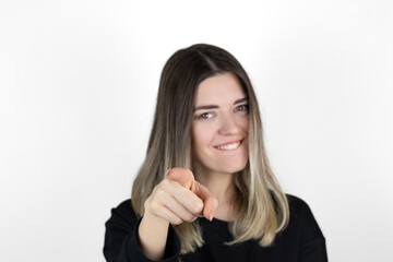 Young beautiful happy woman in studio, pointing at you. Open mouth. Closeup portrait of woman pointing finger at camera. Studio shot, white background. Text, copy and paste space. 
