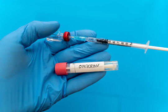 Doctor with protective glove holding swab tube with Omicron and syringe against blue background