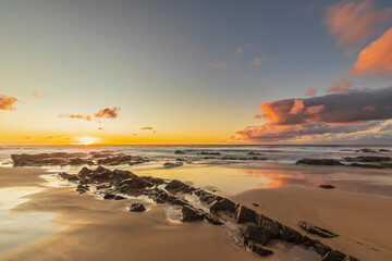 Sandy coastal beach at moody sunrise