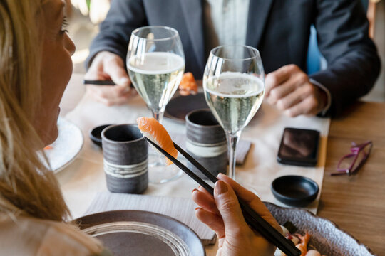 Man and woman eating sushi at lunch date in restaurant