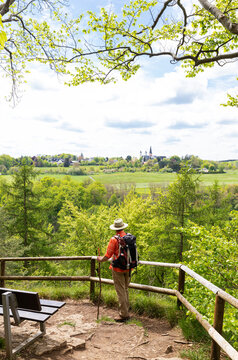 Hiker looking at Salvatorian Monastery Steinfeld from Eifelsteig trail in Eifel, North Rhine Westphalia, Germany