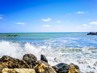 Fototapeta na wymiar Sea shore with blue water, rocks and mistic summer sky
