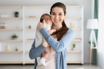 Fototapeta premium Happy Maternity Time. Portrait Of Beautiful Young Mother Embracing Her Newborn Child