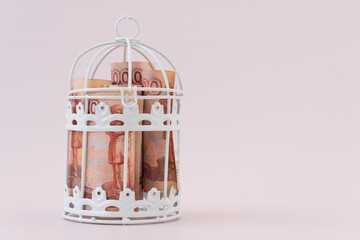 Money is locked in a metal cage. Russian rubles with a face value of 5000. Bills under lock and key. The concept of accumulating money. No investment, no development, money doesn't work.
