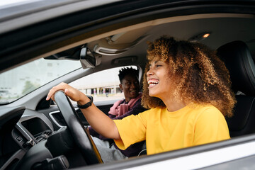 Cheerful young woman with friend in car