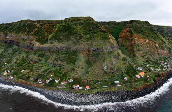 Houses on coast with mountain range at Rocha da Relva, Sao Miguel Island, Azores, Portugal