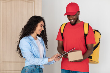 Female Customer Receiving Order Signing Digital Form Standing At Door