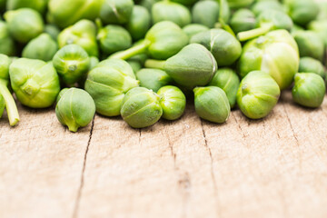 Fresh capers on wooden background.