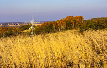 Autumn panoramic view of hills with fields and meadows with field cross shrine surrounding Zagorzyce village south Sedziszow Malopolski town in Podkarpacie region of Lesser Poland - obrazy, fototapety, plakaty