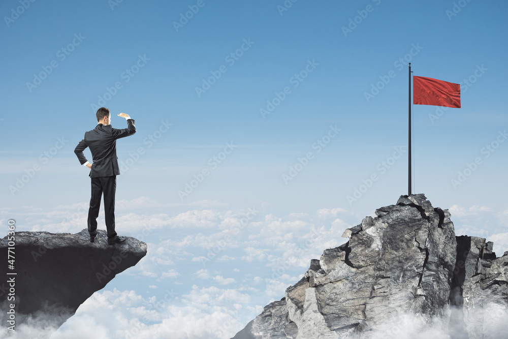 Poster Abstract image of businessman looking into the distance while standing on edge of cliff, mock up place on sky with clouds background, red flag. Success, challenge, future and growth concept.