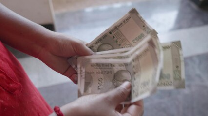 woman counting money Indian currency 500 notes
