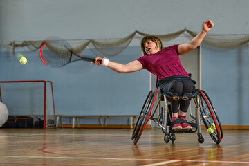 Disabled young woman on wheelchair playing tennis on tennis court