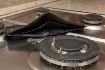 The energy crisis. An empty wallet lies on a disconnected gas cooker. The high cost of gas.