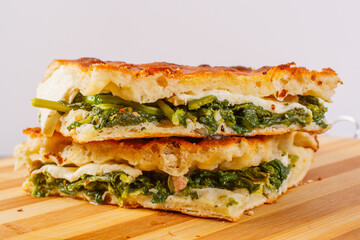 Focaccia croccante appena sfornata ripiena di friarielli, mozzarella di bufala e salsiccia
