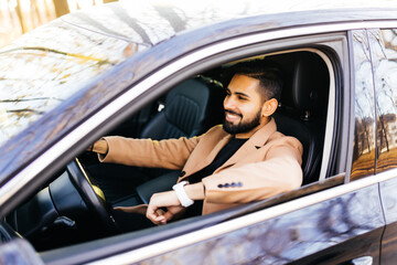 Young indian man driving a car on the street