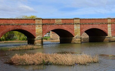  the historical convict-built red bridge over the elizabeth river on a sunny summer day at campbell town in tasmania, australia 