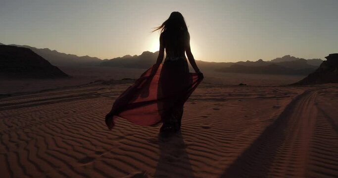 Silhouette of a girl walking in a beautiful sunset in the amazing desert of Wadi Rum, Jordan