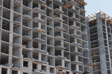 Fototapeta premium Construction of an apartment building. Construction of a multistorey concrete building. Concrete multi-storey building.
