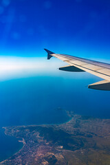 View from the airplane window at a beautiful blue clear sky and the airplane wing