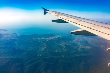 View from the airplane window at a beautiful blue clear sky and the airplane wing