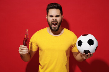 Screaming young bearded man football fan in yellow t-shirt cheer up support favorite team hold...