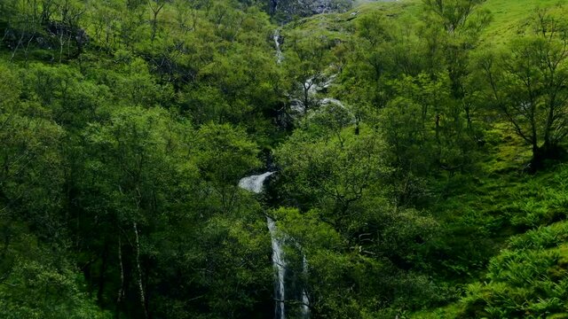 Aerial Drone Shot of Downhill Stream and Waterfall in Glen Coe. High quality video footage