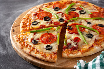 Traditional supreme pizza on black stone