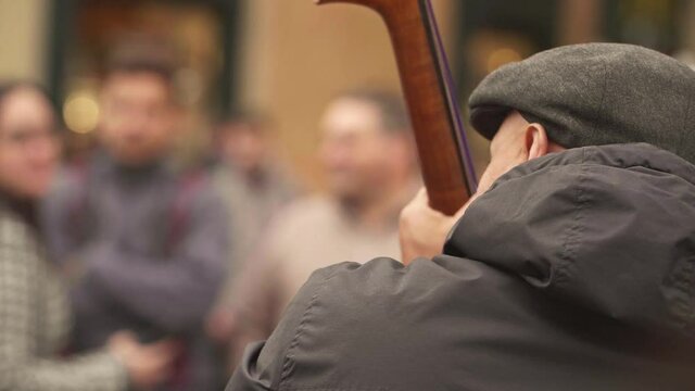 Back Shot Of Busker Playing Chelo. High quality video footage