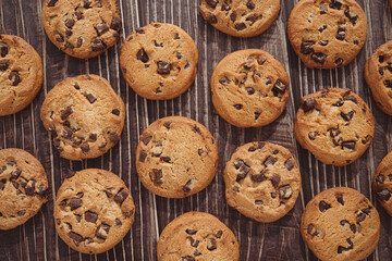 A lot of chocolate chip cookies on the wooden board.