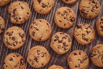 A lot of chocolate chip cookies on the wooden board.