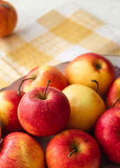Many sweet red apples on a yellow napkin. Diet eating.
