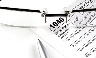 Form 1040 with pen and glasses on the white background