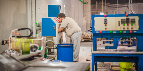 Professional worker technician machinist work on vacuum sandblasting cabinet