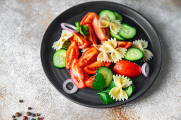 pasta salad no meat tomato, cucumber, farfalle, healthy meal diet snack on the table copy space food background rustic