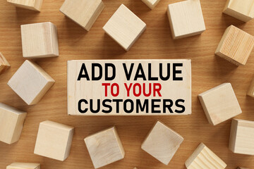 ADD VALUE TO YOUR CUSTOMERS. text on wood block on wood table