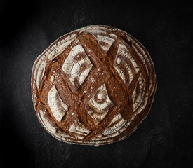 Rustic bread. whole wheat grains on dark background. Top view.