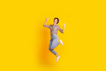 Fototapeta na wymiar Full body profile side photo of young excited woman have fun jump show peace v-symbol isolated over yellow color background