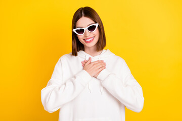 Photo of sincere peaceful lady hands heart wear sunglass white hoodie isolated yellow color background