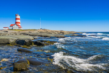 Naklejka premium View on the Pointe des Monts lighthouse, the most famous lighthouse of Cote region of Quebec, Canada
