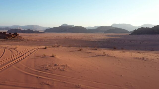 Aerial footage of Wadi Rum desert in Jordan during a beautiful sunrise with the red rocks in the background