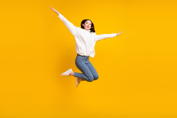 Photo of romantic lady jump plane flight blow air kiss wear white hoodie jeans shoes isolated yellow color background
