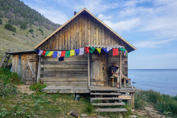 Hiker near a wooden hut on Lake Baikal
