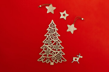 Naklejka na ściany i meble wooden decorative decoration of fir-tree, star and deer on red background