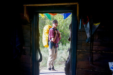 Obraz na płótnie Canvas Hiker near a wooden hut on Lake Baikal