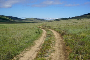 Fototapeta premium Dirt road through a beautiful valley on Olkhon island
