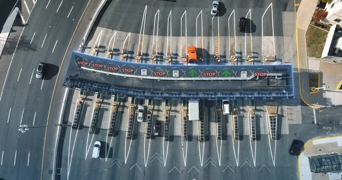 Top down aerial of highway with toll plaza. Traffic stops to pay fare to enter. Visual effect with stop go electronic reading and signs.