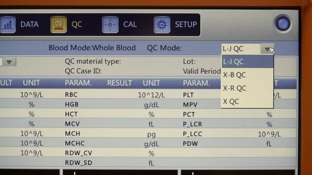 Blood CBC machine screen being configured to show test result. Close up, tilt down
