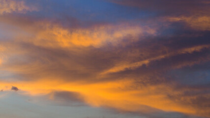 Fototapeta na wymiar Ciel orangé pendant le coucher du soleil, par un temps partiellement nuageux