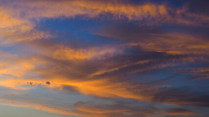 Naklejka na ściany i meble Ciel orangé pendant le coucher du soleil, par un temps partiellement nuageux